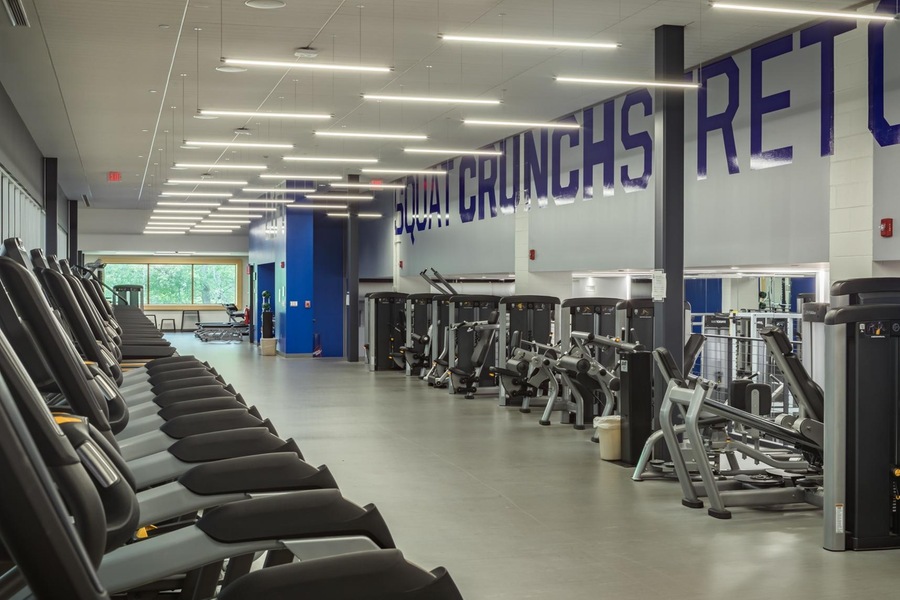 Wellesley College Fitness Center, treadmills and weightlifting equipment in blue and white room.