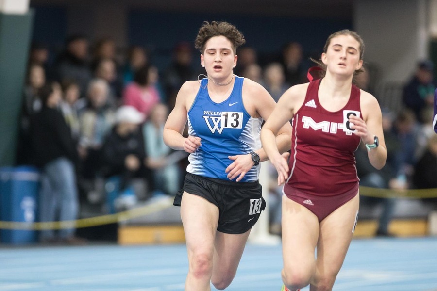 Two runners on indoor track, Wellesley and MIT.