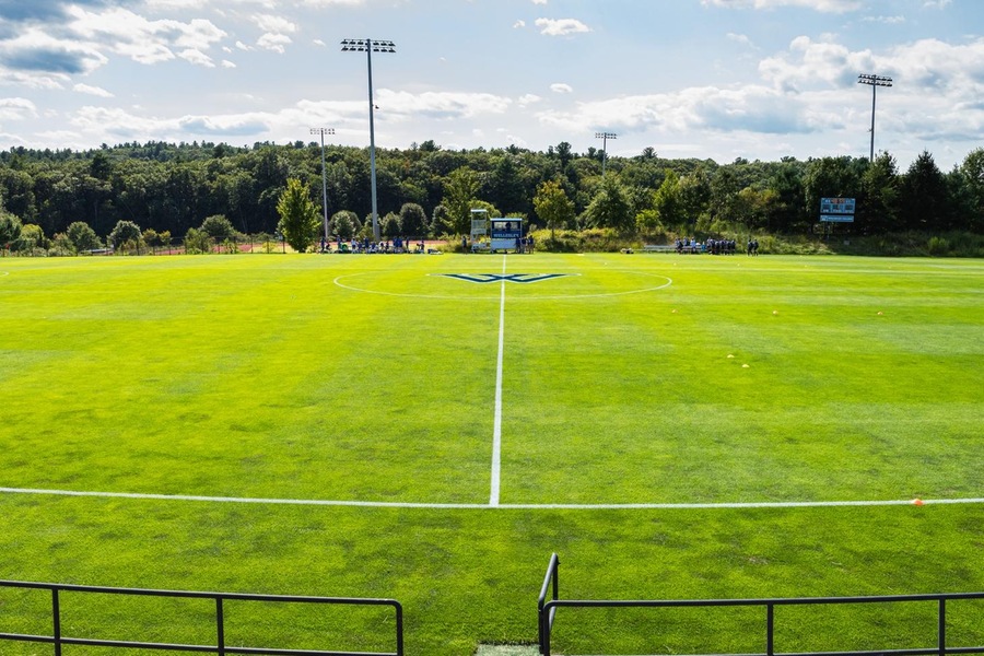 green soccer field, panoramic view from center line on a bright day