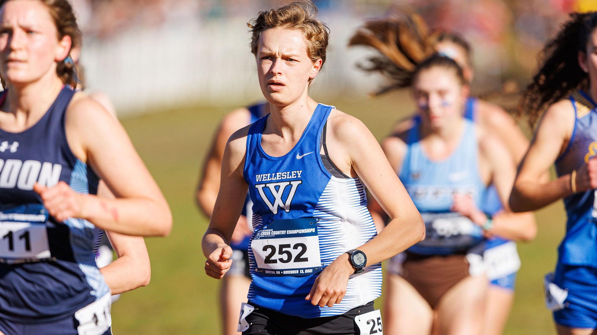 women's cross country runner in blue Wellesley uniform